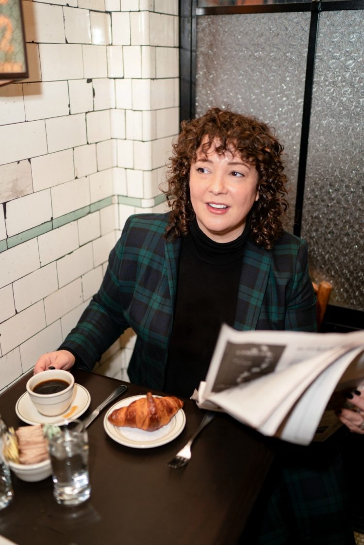 Charles Perri of Wardrobe Oxygen in a Talbots plaid blazer and black turtleneck enjoying a croissant and cup of coffee at Pastis NYC