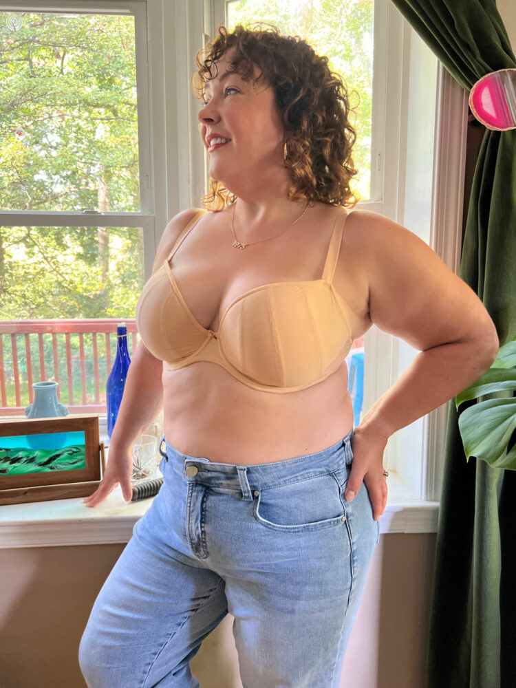 Over 40 woman wearing the Bravissimo Niya Bra in beige with a pair of jeans