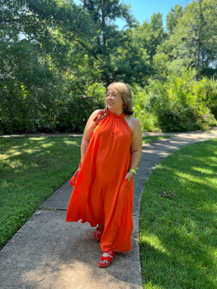 Alison in an orange halter neck maxi dress from COS with red Birkenstocks.