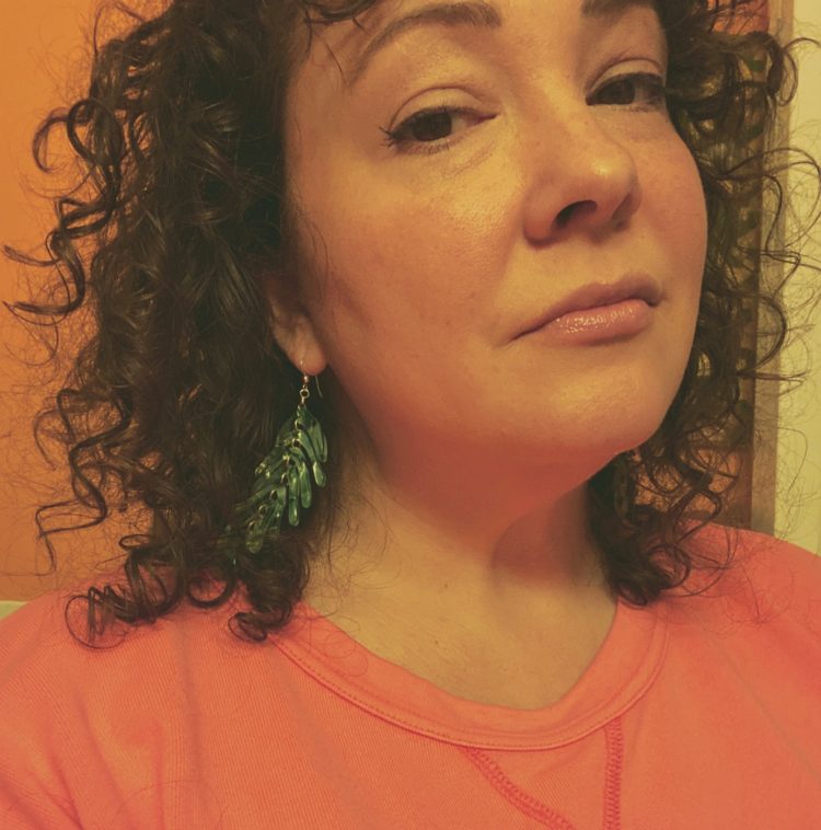 woman wearing a pair of green lucite earrings from Black woman-owned jewelry company Covet San Francisco