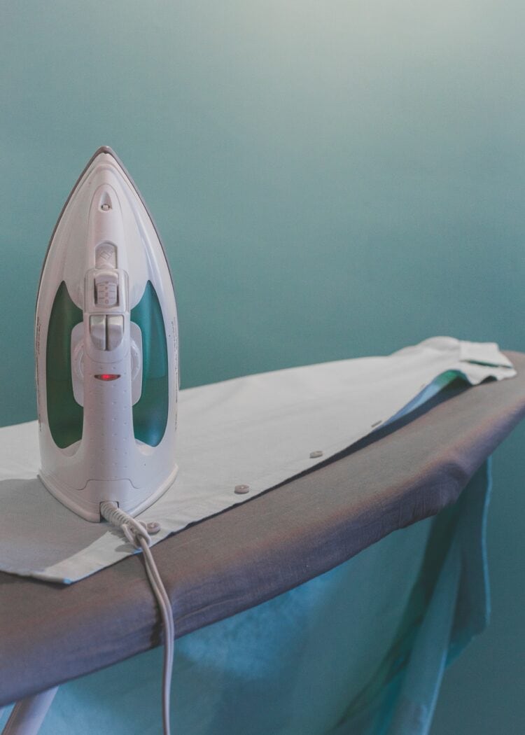 an iron and linen shirt on an ironing board