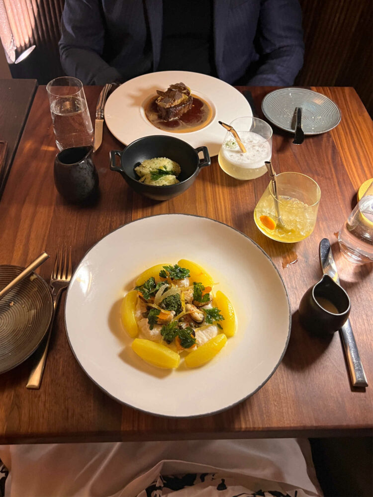 two plates on a table at L'Avant-Garde DC, once with the chilean sea bass and one with filet mignon.