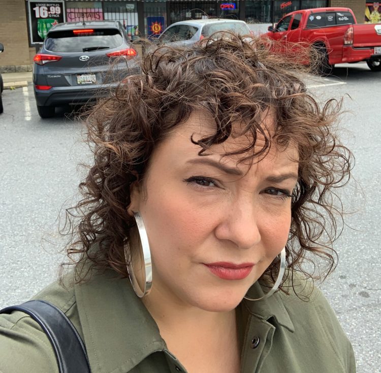 Woman with scowl on her face and frizzy greasy hair