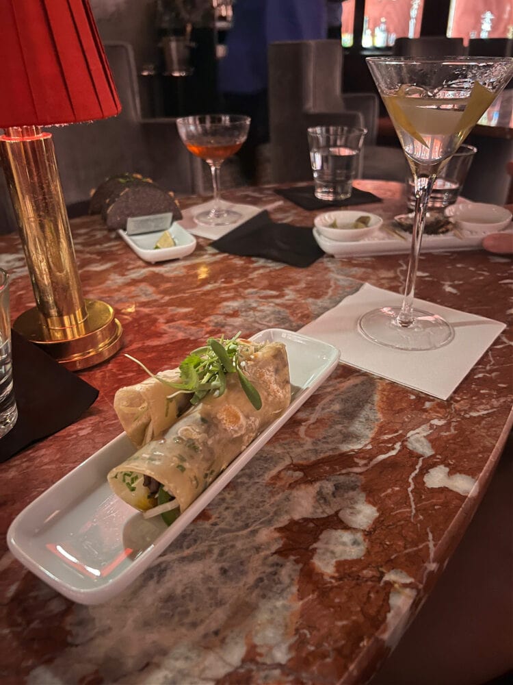 A table of cocktails and jerk mushroom rolls at Silver Lyan, the basement bar and restaurant at the Hotel Riggs Washington DC