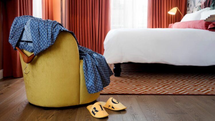 A photo of a room at the Hotel Riggs Washington DC featuring the slippers and bathrobe that come with each hotel room