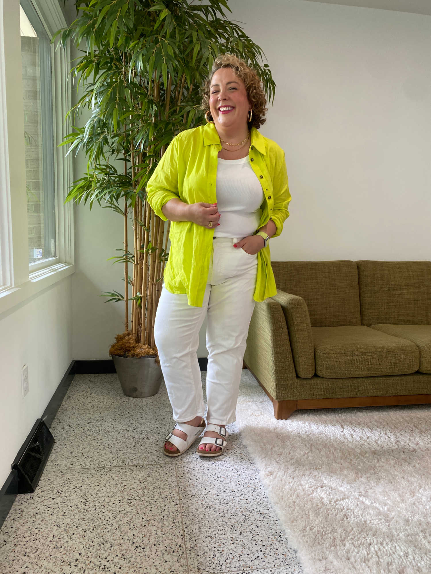 woman in neon yellow linen shirt, white tank, and white Universal Standard Etta jeans