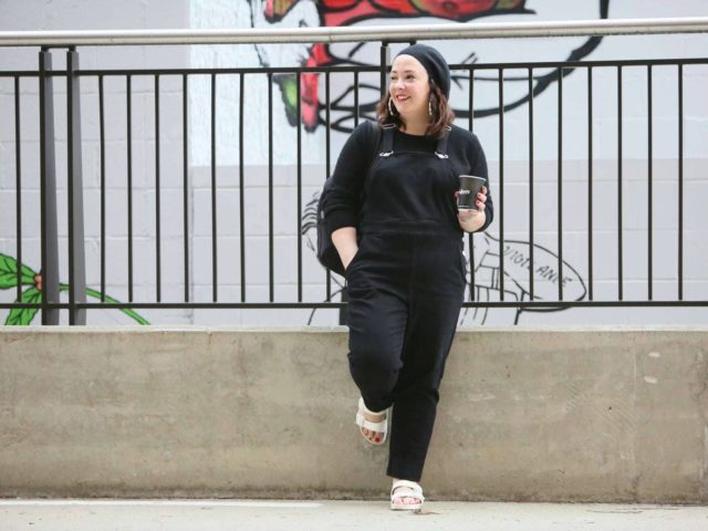 Universal Standard black overalls with a black cashmere sweater, EVA Birkenstocks, and the Dagne Dover Dakota backpack on Wardrobe Oxygen